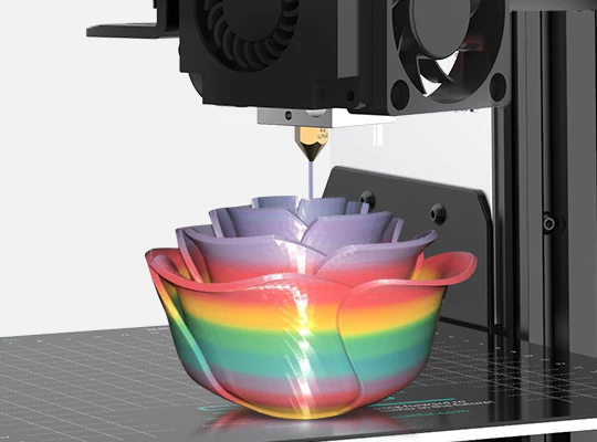 Impresora 3D en acción imprimiendo un florero en forma de rosa con Filamento Sunlu PETG Arcoíris. La impresión presenta una transición suave de colores vibrantes y un acabado brillante. Disponible en Smartec Store Quito Ecuador.
